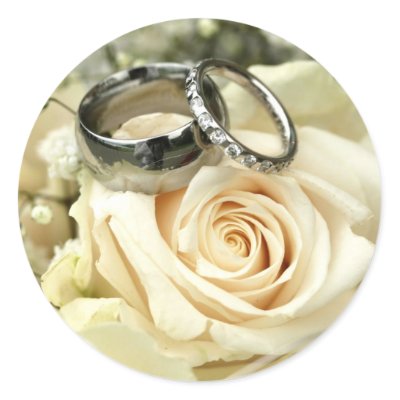 Wedding stickers with wedding rings on a bridal bouquet of roses