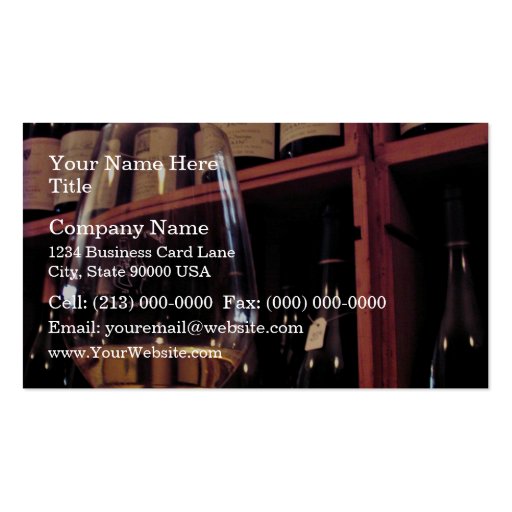 Wine glass with bottles in background business card (front side)