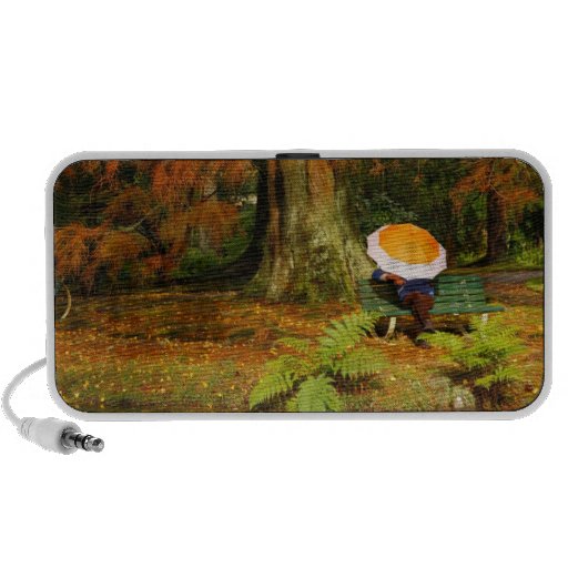 Woman siting with umbrella travelling speakers
