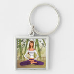 Woman sitting in lotus position, meditating key chains