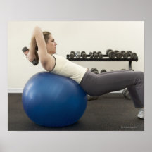Woman using exercise ball and hand weights poster