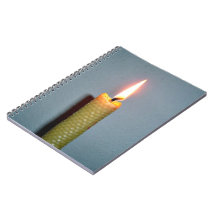 Yellow Candle flame against white wall Note Books