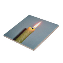 Yellow Candle flame against white wall Tiles