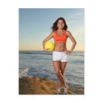 young fit pretty female holding a volleyball at post cards