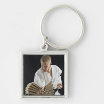 Young man breaking boards with karate chop on keychains
