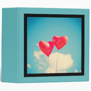 2 Bright Red Heart Shaped balloons Floating Upward Binder