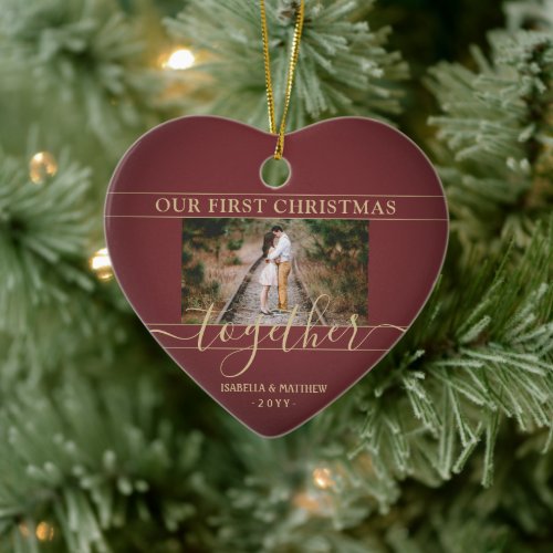 2 Photo First Christmas Together Red & Gold Heart Ceramic Ornament - Celebrate the joyful 1st holiday of your relationship or engagement with a custom heart-shaped 2 photo "Our First Christmas Together" ceramic ornament. All text and images on this template are simple to personalize. (IMAGE PLACEMENT TIP: An easy way to center a photo exactly how you want is to crop it before uploading to the Zazzle website.) As an idea, the script typography can read "Engaged" or "Married." Design features a stylish burgundy red ombre and gold border, handwritten style calligraphy, the couple's names & year, and two pictures of your choice. Please note that gold is printed color, not metallic foil. This unique romantic keepsake adds an elegant touch to Xmas home decorations or makes a thoughtful wedding gift idea.