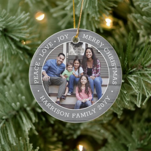 2 Photo Peace Love Joy Merry Xmas Faux Gray Wood Ceramic Ornament - Celebrate the simple joys of the holidays with a custom two photo faux wood round ceramic ornament. All text and pictures on this template are simple to personalize and can be different or the same on front and back. If preferred, change "Peace Love Joy Merry Christmas" to any quote or saying. (IMAGE & TEXT DESIGN TIPS: 1) To adjust position of wording, add spaces at beginning or end. 2) To center the photo exactly how you want, crop it into a square shape before uploading to the Zazzle website.) Modern farmhouse style design features a rustic grey faux wood background, stylish typography name and year, and 2 images of your choice. This unique family keepsake adds an elegant touch to Xmas home decorations.