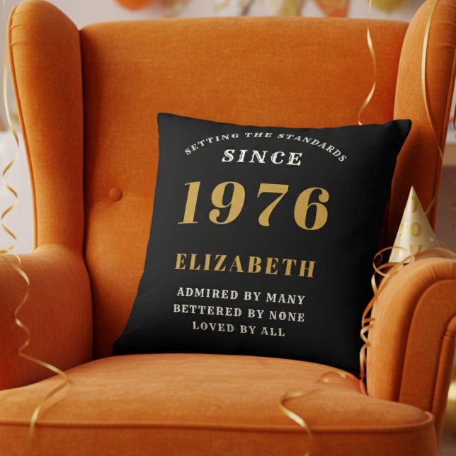 50th Birthday Gift Personalized 1976 Black Gold Throw Pillow (Personalized 50th birthday pillow on a vibrant orange velvet wingback chair)
