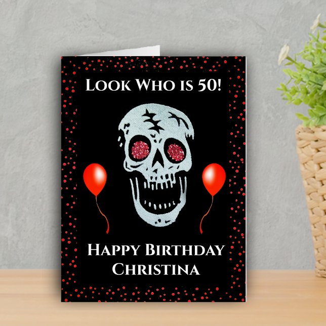 50th Birthday Laughing Skull Red Eyes Black Card (Laughing skull red eyes bright balloons on over the hill 50th birthday oversized greeting card.)