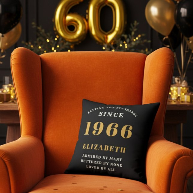 60th Birthday Gift Personalized 1966 Black Gold Throw Pillow (A personalized black pillow on a vibrant orange velvet wingback armchair )