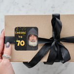 70th birthday cheers to 70 gold balloon text black square sticker<br><div class="desc">A trendy 70th birthday party sticker. With the text: Cheers to 70 on front written with faux gold balloon letters. Black background with golden confetti. Template for your photo.</div>