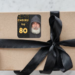 80th birthday black fold cheers men square sticker<br><div class="desc">A trendy 80th birthday party sticker. With the text: Cheers to 80 on front written with faux gold balloon letters. Black background with golden confetti. Template for your photo.</div>