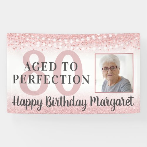 80th Birthday Rose Gold Glitter Photo Banner - Rose gold glitter and string lights birthday banner for any age birthday personalized with her photo and your custom text. The sample shows AGED TO PERFECTION over the editable age 80 and the editable greeting HAPPY BIRTHDAY NAME. PHOTO TIP:  For fastest/best results, choose a photo with the subject in the middle and/or pre-crop it to a square shape BEFORE uploading and use the CHANGE tab next to the sample photo in the PERSONALIZE section. Contact the designer via Zazzle Chat or makeitaboutyoustore@gmail.com if you'd like this design modified or on another product.