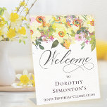 90th Birthday Yellow Daffodil Wildflower Welcome Pedestal Sign<br><div class="desc">Pretty springtime flower arrangement features yellow daffodils and purple wildflowers nestled in greenery. This tabletop sign stands up on its own. Just one less thing to think about, right? The calligraphy adds an elegant touch. This item is part of the Rustic Boho Yellow Daffodil collection. It lets you choose a...</div>