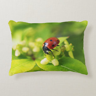 A beautiful shiny ladybug on green leaves accent pillow
