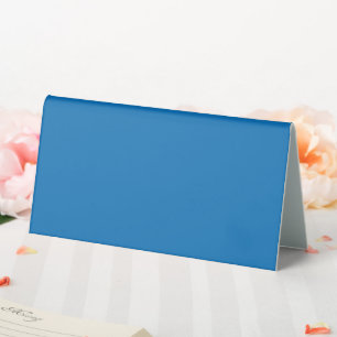 a blue background with a black and white clock table tent