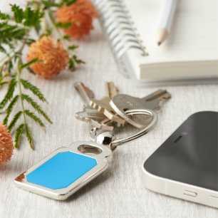a blue sky with a plane flying in the sky keychain