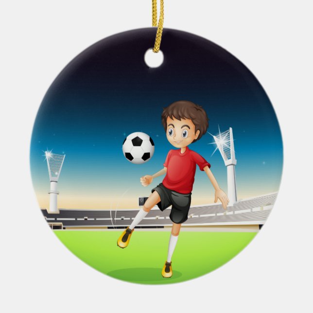 A boy playing soccer alone ceramic ornament (Front)
