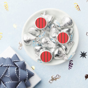 A bright red apple sits on a plain white surface. hershey®'s kisses®