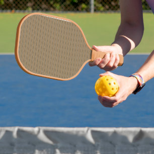 a brown and beige striped background carbon fiber pickleball paddle