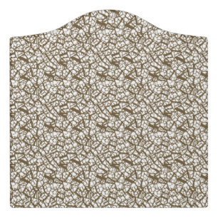 A brown rug with a geometric motif is partially co door sign