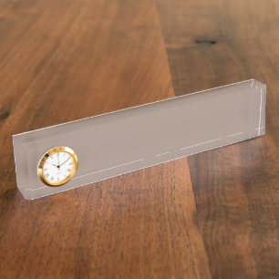 a brown wall with a clock on it desk name plate