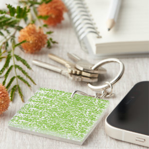 A brown wooden table holds a glass bottle of olive keychain