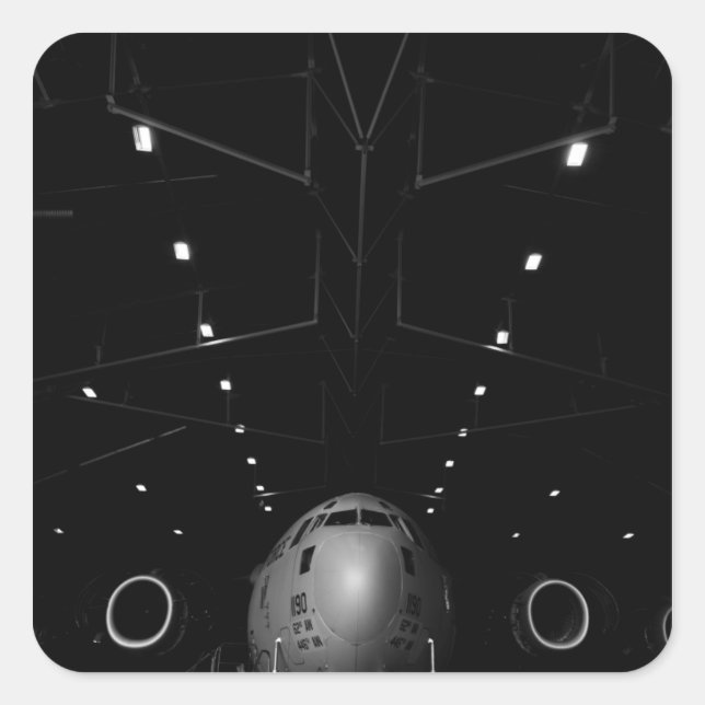 A C-17 Globemaster III sits in a hangar Square Sticker (Front)
