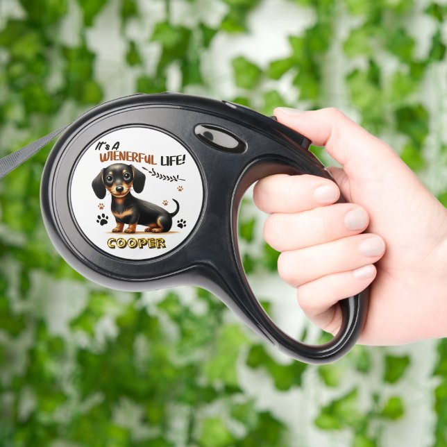 A cheerful dachshund embracing a wienerful life retractable pet leash  (Hand)