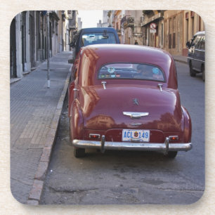 A classic old red Peugeot car parked on a street Coaster