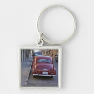 A classic old red Peugeot car parked on a street Keychain
