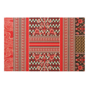 A close-up of red and black patterned fabric showc wood wall art