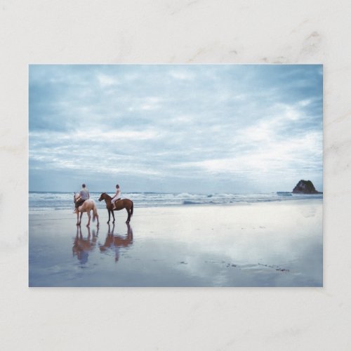 A couple riding horses on Parkiri beach in New Postcard