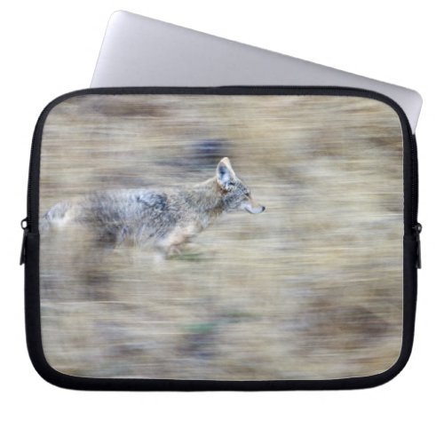 A coyote runs through the hillside blending into laptop sleeve