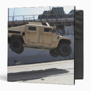 A crane lifts an M998 Humvee Binder