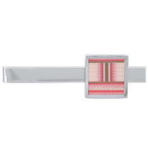 a cross stitch pattern with a red background silver finish tie bar