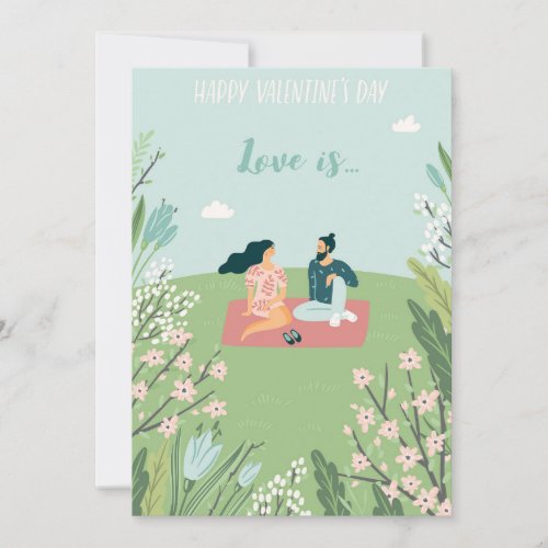 A cute couple sitting in a flower garden holiday card