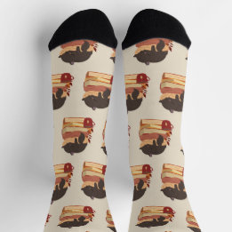 A cute kitten sleeping curled up on a pile of book socks