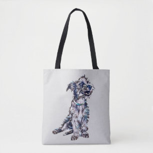 A cute scruffy terrier mixed breed dog with a gree tote bag