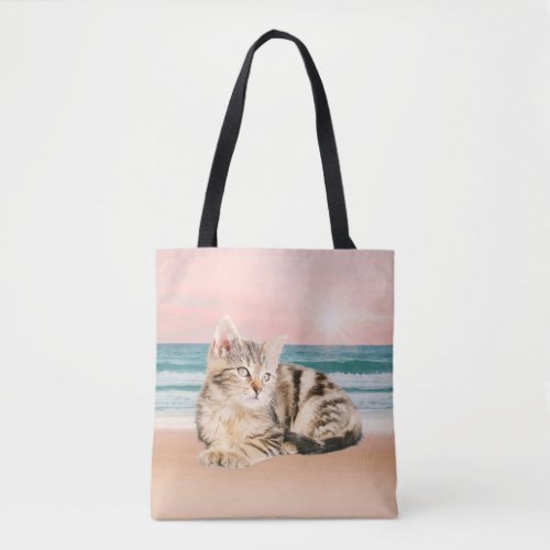 A Cuter Striped Cat Sitting on Beach with sunset Tote Bag