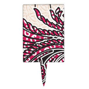 A decorative paisley design with vivid red and pin cake topper