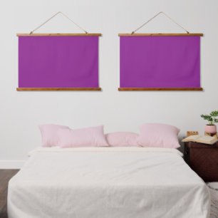 A deep purple background accented by a bright whit hanging tapestry