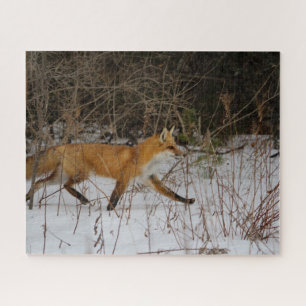 A fox strolling through the snow on a wintry day jigsaw puzzle