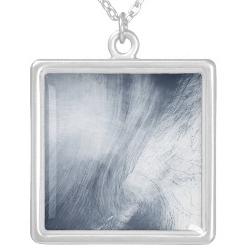 A giant whirlpool cloud swirls above the sea silver plated necklace