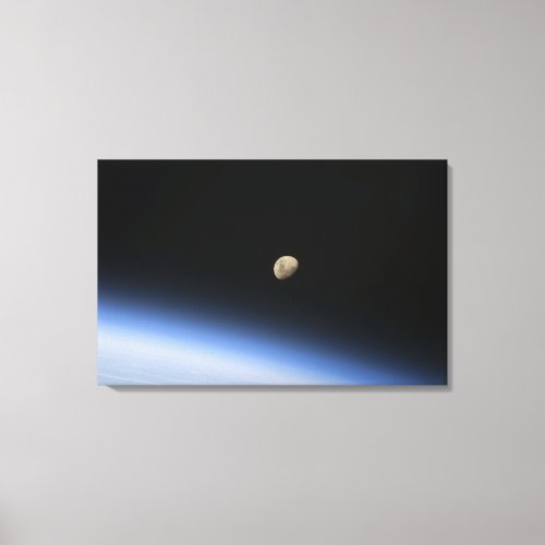 A gibbous moon visible above Earths atmosphere 2 Canvas Print