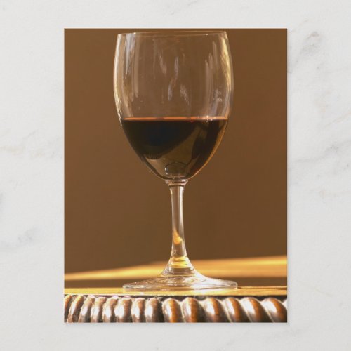 A glass of red Chateau Belgrave in sunlight _ Postcard