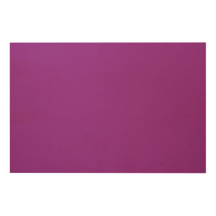 A gradient background blending shades of pink and wood wall art