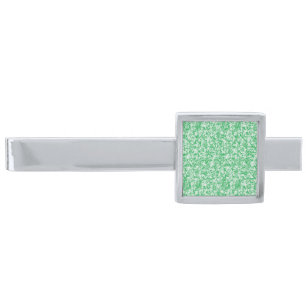 a green and white background with small white dots silver finish tie bar