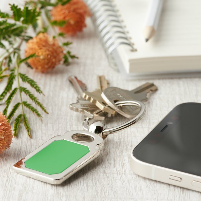 a green background with a white border keychain (Side)